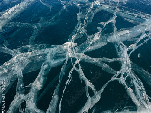 Network of cracks in thick solid layer of ice of a frozen Baikal lake in Siberia (Russia)