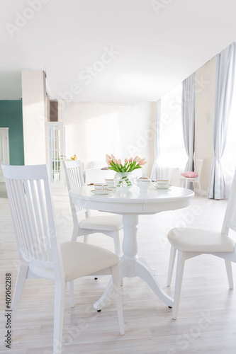 Luxurious and expensive interior of an open-plan apartment in light colors. Stylish modern bedroom with minimal design, dining area and guest space.