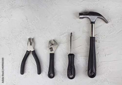 Construction tools, hammer, pliers, wrench, screwdriver flat lay on concrete background 