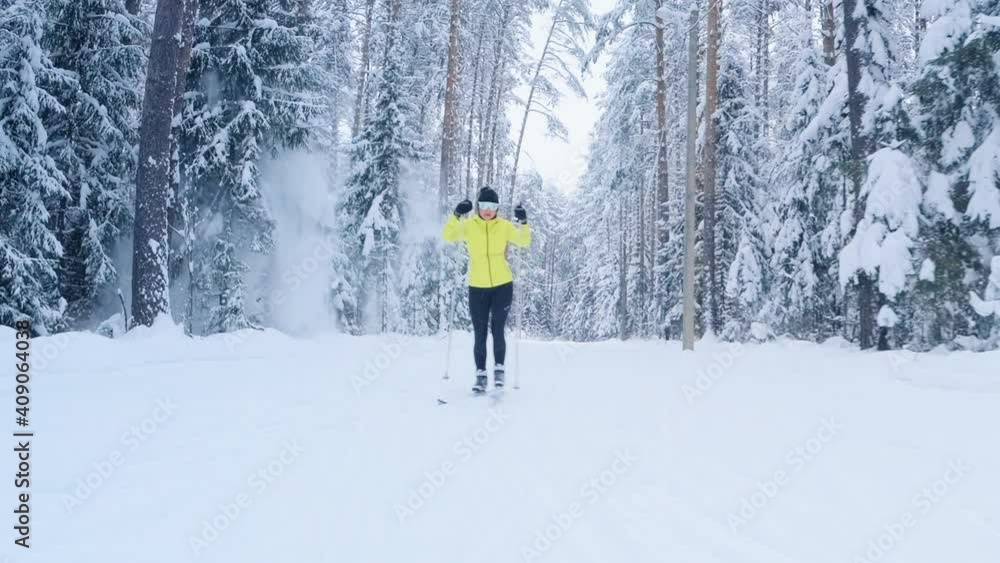 Cross country ski. Woman skier works out on the skating ski track in the winter forest with snow covered trees Cross country ski. Woman skier works out on the skating ski track in the winter forest with snow covered trees
