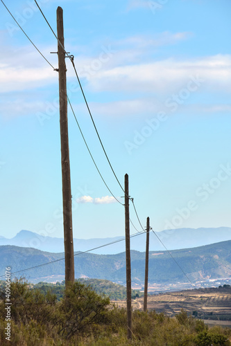Fotografie Three old phone or electricity poles made of wood on the top of a mountain