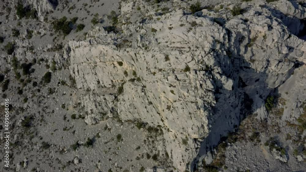 Aerial revealing shot of a motor road with cars in the Croatian coast. Drone flying over the rocky mountains on a top down view. Aerial revealing shot of a motor road with cars in the Croatian coast. Drone flying over the rocky mountains on a top down view.