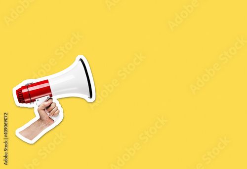 Hand holding megaphone on bright yellow background with plenty of copy space. Magazine collage cut out style