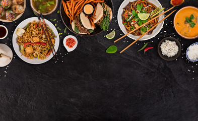 Asian food served on black stone table, top view, space for text. Chinese and vietnamese cuisine set.