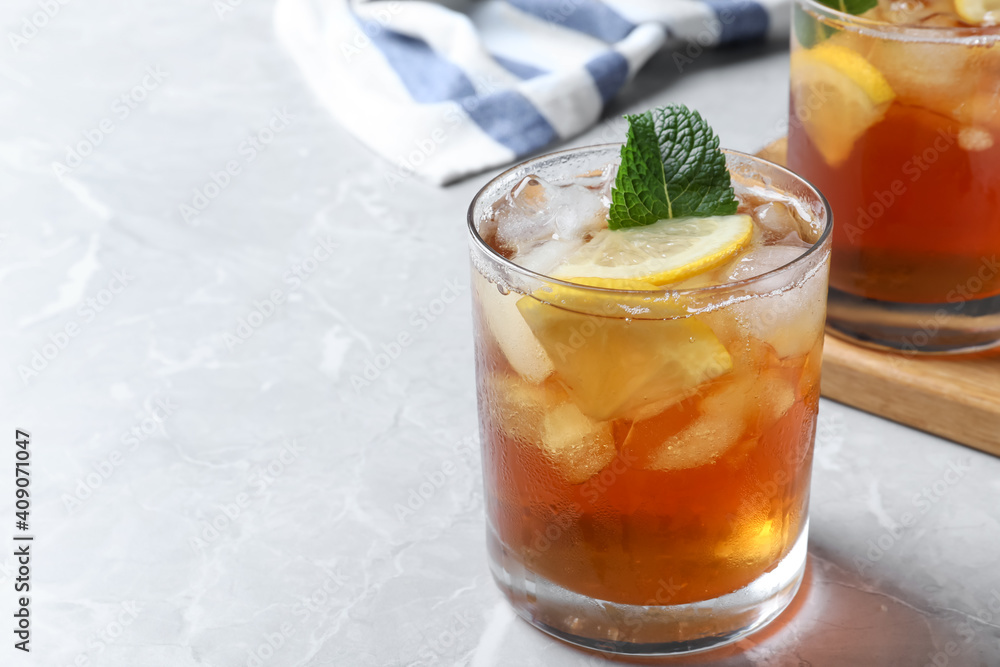 Delicious iced tea in glass on light grey marble table. Space for text