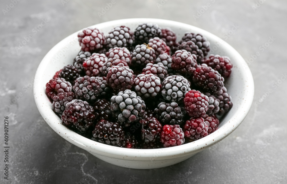 Tasty frozen blackberries in bowl on grey table, closeup Tasty frozen blackberries in bowl on grey table, closeup