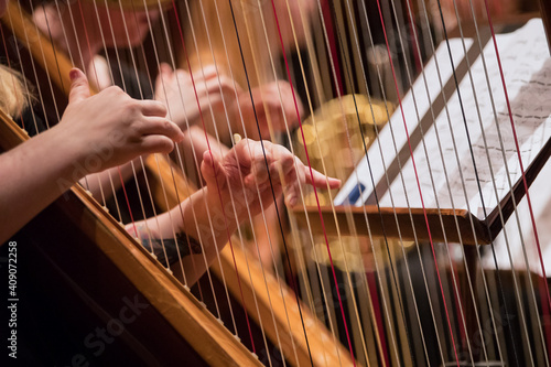 Fotótapéta Harp professional player with symphony orchestra performing in concert on background