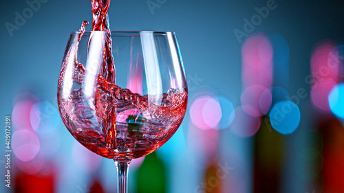 Fotografie Pouring red wine in a bar, close-up.