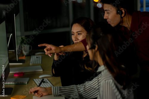 Asian business employee working in call center customer service office in the night 