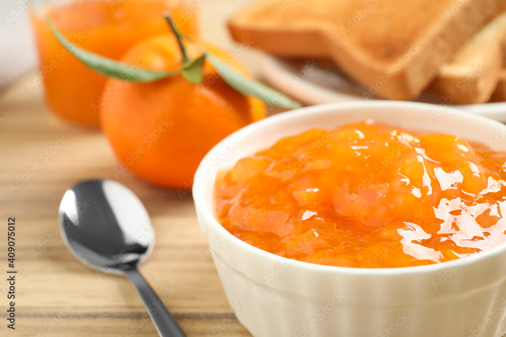 Tasty tangerine jam in bowl on wooden table, closeup Tasty tangerine jam in bowl on wooden table, closeup