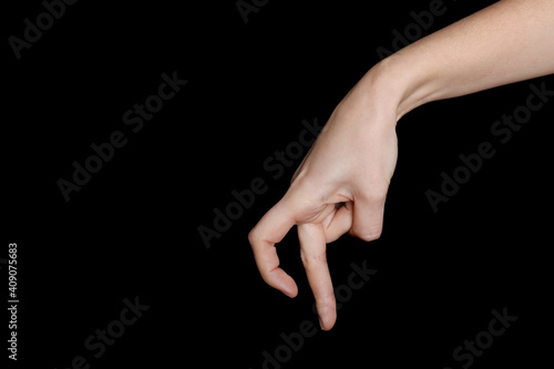 Woman imitating walk with hand on black background, closeup. Finger gesture