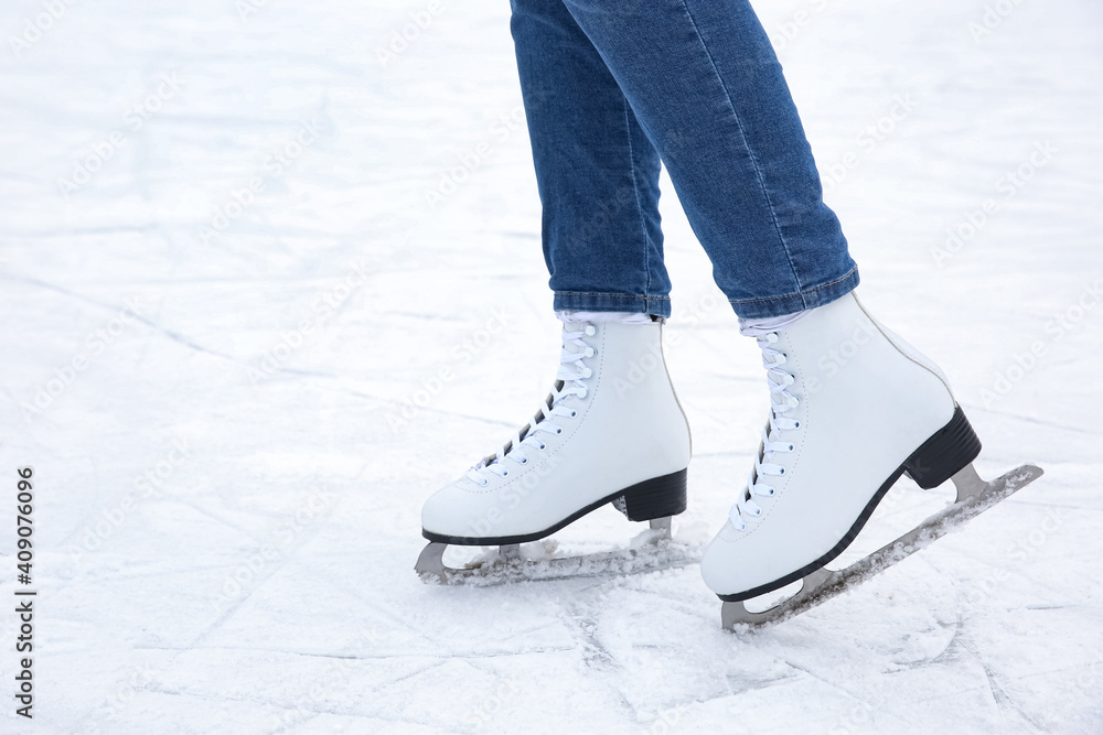 Woman wearing figure skates on ice rink, closeup. Space for text Woman wearing figure skates on ice rink, closeup. Space for text