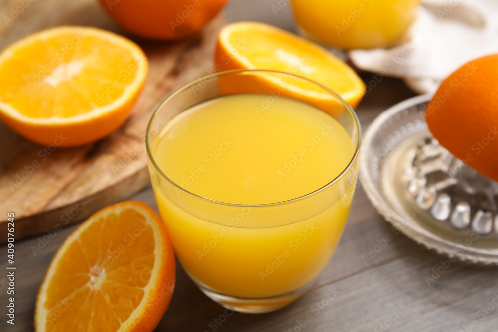 Fresh ripe oranges and glass of juice on wooden table, closeup Fresh ripe oranges and glass of juice on wooden table, closeup