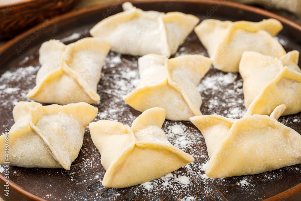 Cooking, cooking homemade ravioli, dumplings or meat dumplings on a wooden table. The view from the top Cooking, cooking homemade ravioli, dumplings or meat dumplings on a wooden table. The view from the top