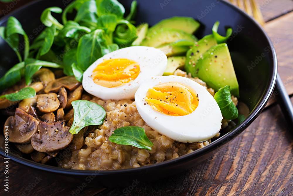 Breakfast oatmeal porridge with boiled egg, avocado and fried mushrooms. Healthy balanced food. Breakfast oatmeal porridge with boiled egg, avocado and fried mushrooms. Healthy balanced food.