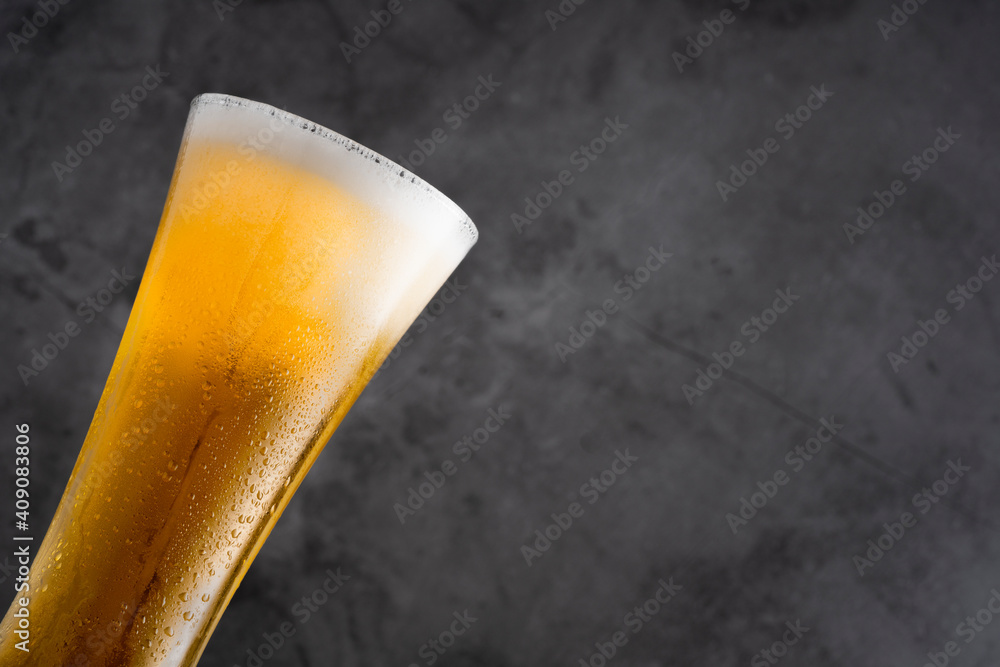 Cold beer with foam on black backgound