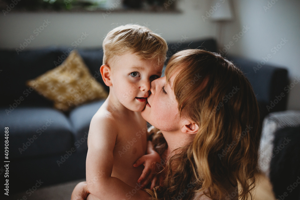Close up of a blonde mother and son hugging at home Close up of a blonde mother and son hugging at home