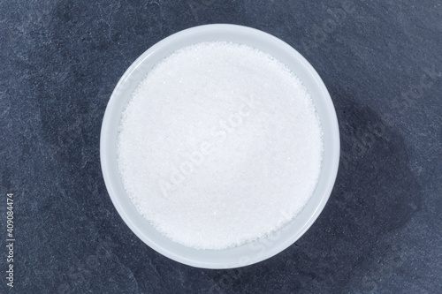 Sugar from above bowl on a slate