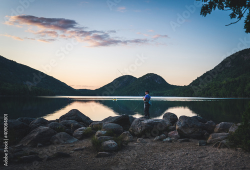 Man standing with fly fishing rod at Jordan Pond, Acadia National Park photo