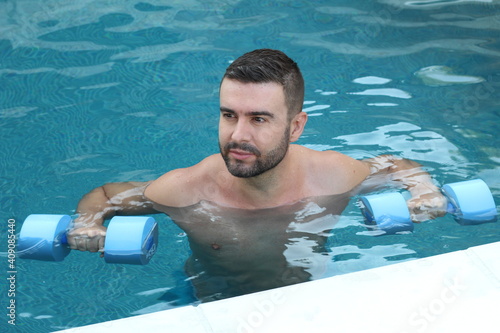 Young man exercising in swimming pool photo