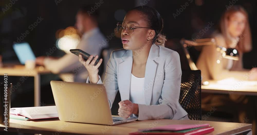 African american attractive office manager using laptop computer talking on the phone performing marketing duties in modern office late night. African american attractive office manager using laptop computer talking on the phone performing marketing duties in modern office late night.