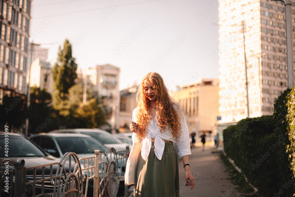 Thoughtful young woman walking on sidewalk in city during summer Thoughtful young woman walking on sidewalk in city during summer