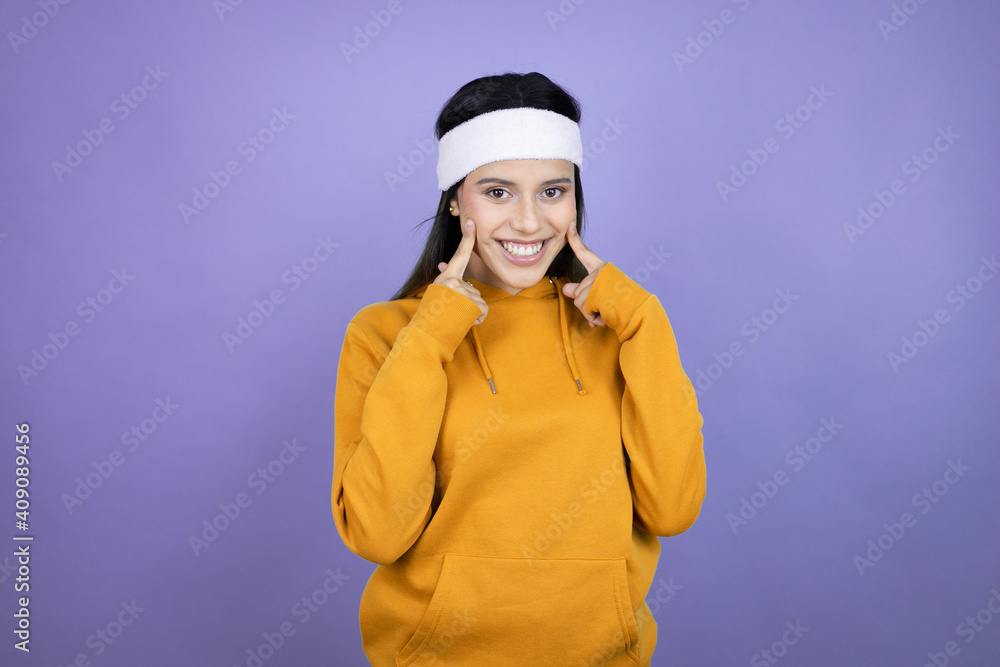 Young latin woman wearing sportswear over purple background smiling confident showing and pointing with fingers teeth and mouth Young latin woman wearing sportswear over purple background smiling confident showing and pointing with fingers teeth and mouth