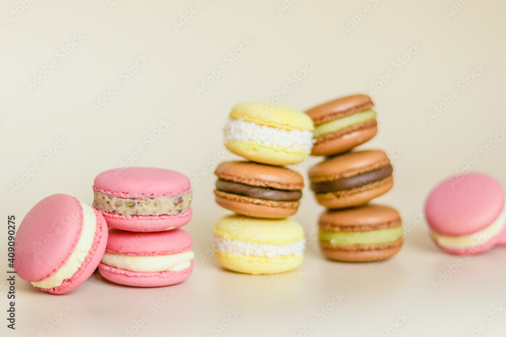Many multi colored macaroon cakes in stacks on a light background Many multi colored macaroon cakes in stacks on a light background