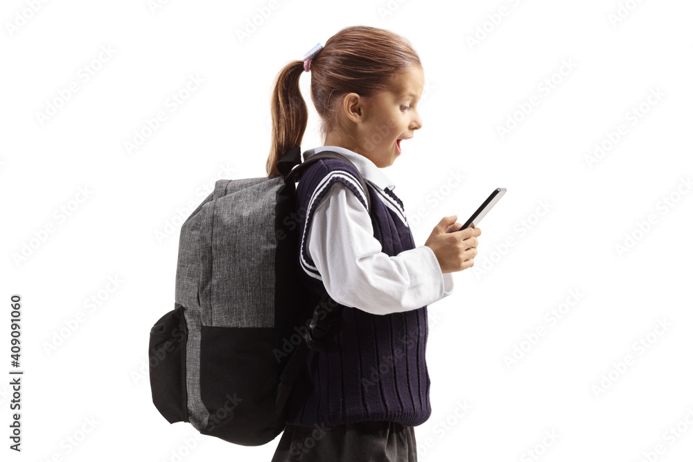 Happy schoolgirl standing and looking at a mobile phone Happy schoolgirl standing and looking at a mobile phone