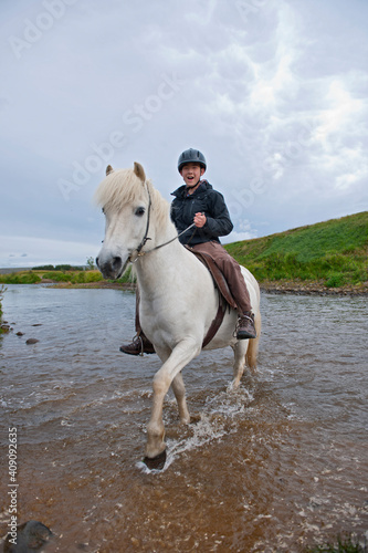 teenage boy riding Icelandic horse in remote location photo