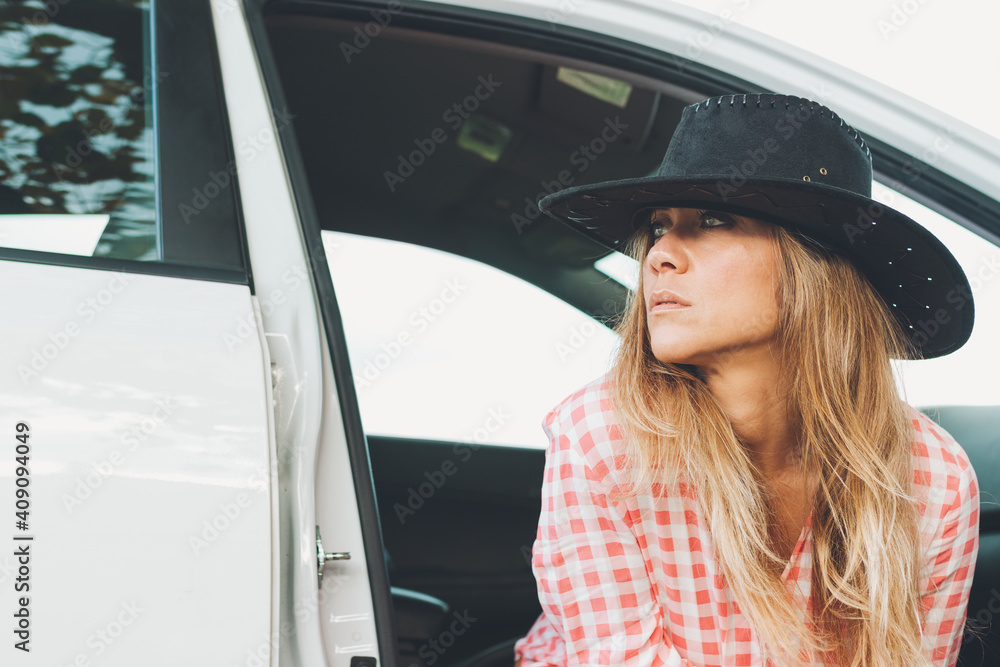 Attractive Woman In Cowgirl Hat Sitting In The Door Of A White Car Attractive Woman In Cowgirl Hat Sitting In The Door Of A White Car