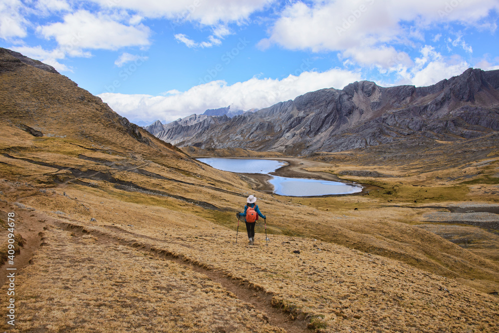 A trekker with Laguna Susucocha on the background from Tapush Punta on the Cordillera Huayhuash circuit, Ancash, Peru