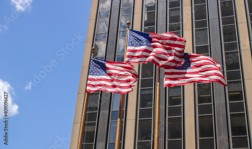 Waving stars and stripes in front of an skyscraper or office building in summer