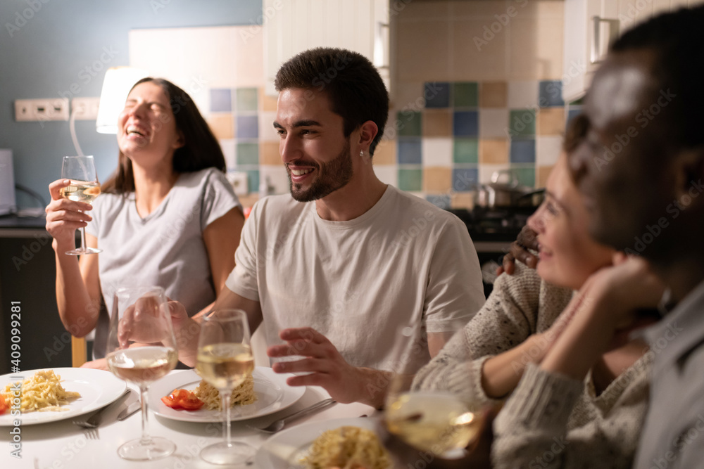 Young man telling stories to diverse friends during party Young man telling stories to diverse friends during party