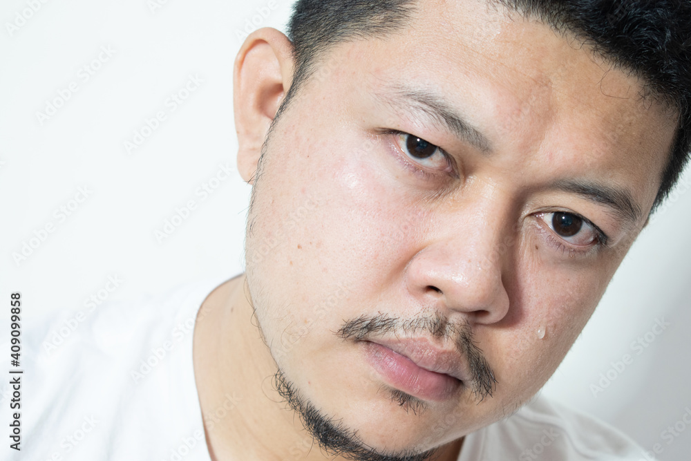 Obraz premium Portrait of unhappy and depressed man with black hair, feeling ashamed or sick, keeping eyes closed. Human face expressions and emotions concept. Isolated studio shot on gray background.