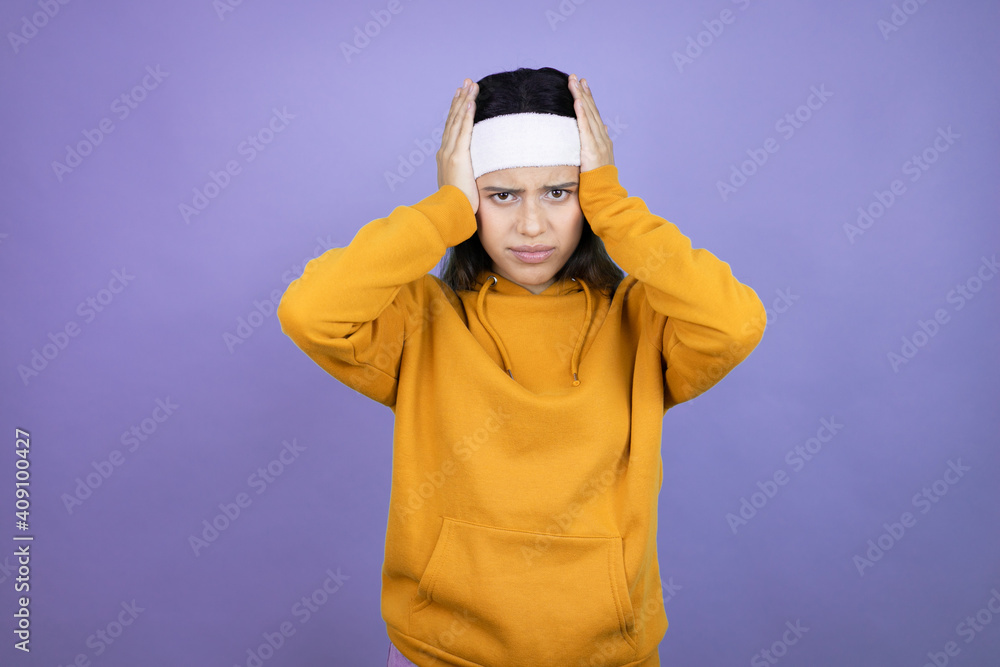 Young latin woman wearing sportswear over purple background thinking looking tired and bored with hands on head Young latin woman wearing sportswear over purple background thinking looking tired and bored with hands on head