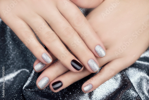 Silver manicure. Women s hands with beautiful manicure on a silvery shiny background.