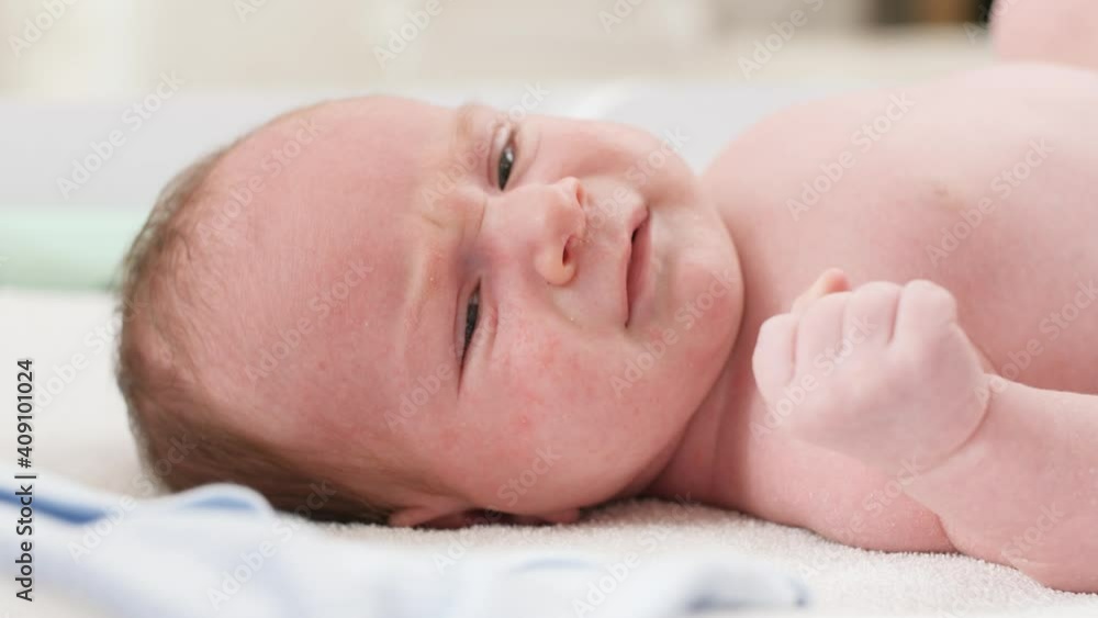 Closeup portrait of cute little newborn baby boy lying on changing table. Concept of babies and newborn hygiene and healthcare. Caring parents with little children. Closeup portrait of cute little newborn baby boy lying on changing table. Concept of babies and newborn hygiene and healthcare. Caring parents with little children.