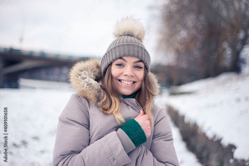 Girl in a warm hat in winter, happy woman laughs, positive emotions Girl in a warm hat in winter, happy woman laughs, positive emotions