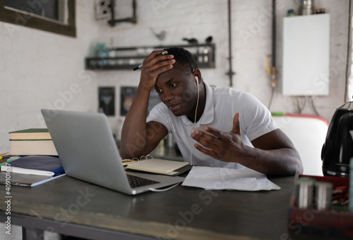 Frustrated ethnic student during online lesson