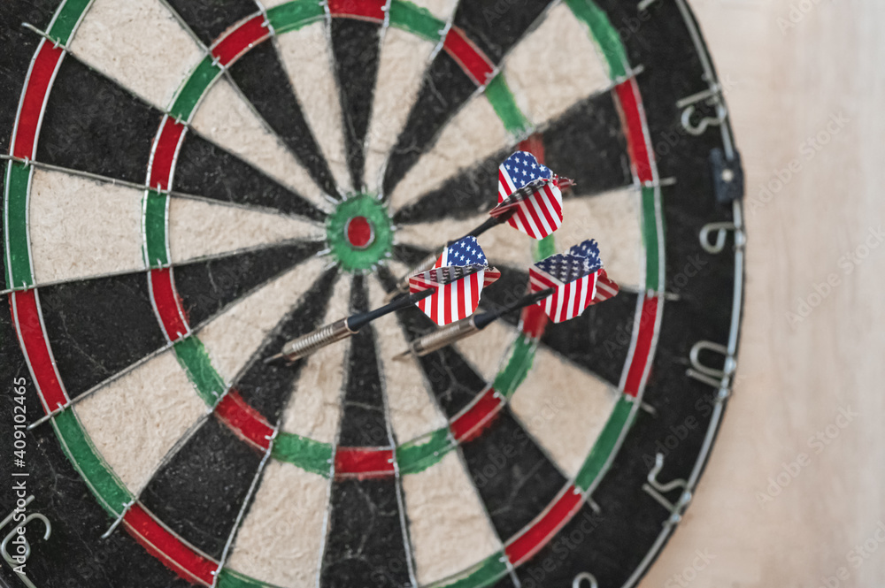the dart's arrows hit an old dartboard.