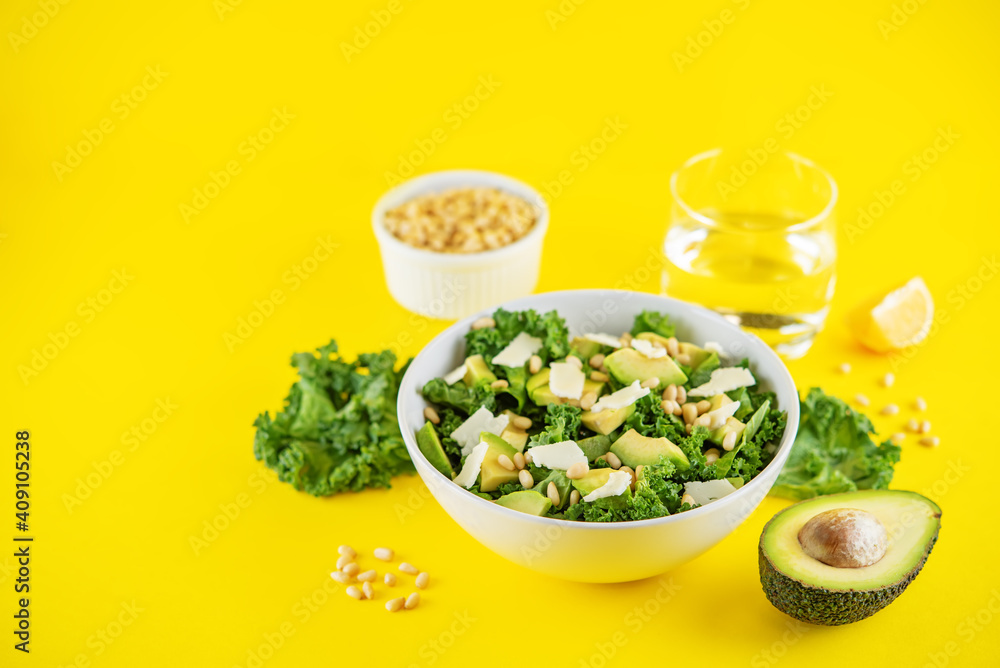Kale avocado pine nuts cheese salad with lemon dressing in a bowl Kale avocado pine nuts cheese salad with lemon dressing in a bowl