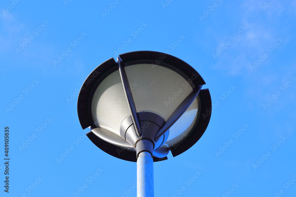 isolated glass and metal street lamp post with the blue sky in the background isolated glass and metal street lamp post with the blue sky in the background