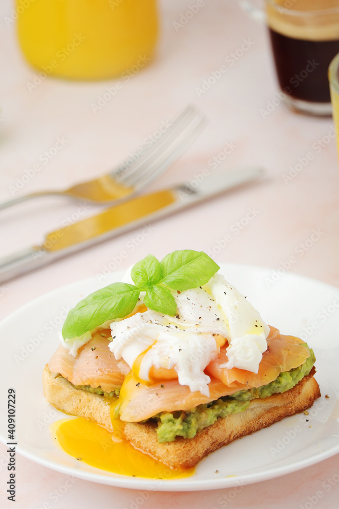 Breakfast with a sandwich with poached egg and avocado