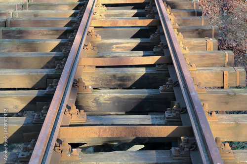 closeup of an old rusty tram tracks at a wooden bridge