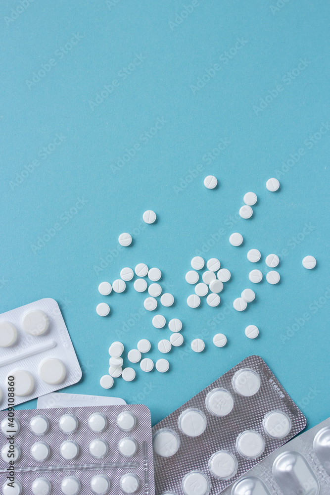 White pills flat lay for blogger medicine content with copy space on blue background