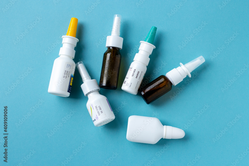 Bottles of nasal spray on blue background, medicine flat lay, treatment for colds Bottles of nasal spray on blue background, medicine flat lay, treatment for colds