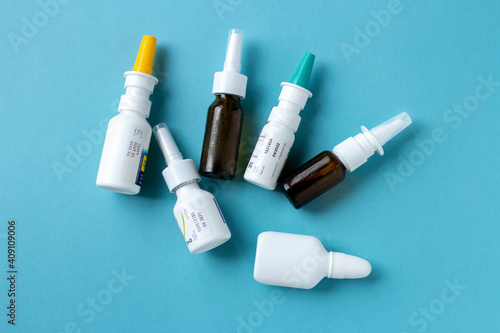 Bottles of nasal spray on blue background, medicine flat lay, treatment for colds