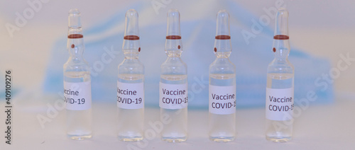ampoules with Covid-19 vaccine on a laboratory on the table, syringe
