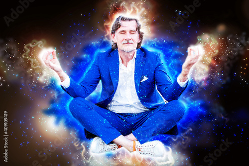 handsome businessman in blue suit in his 50s meditating and glowing